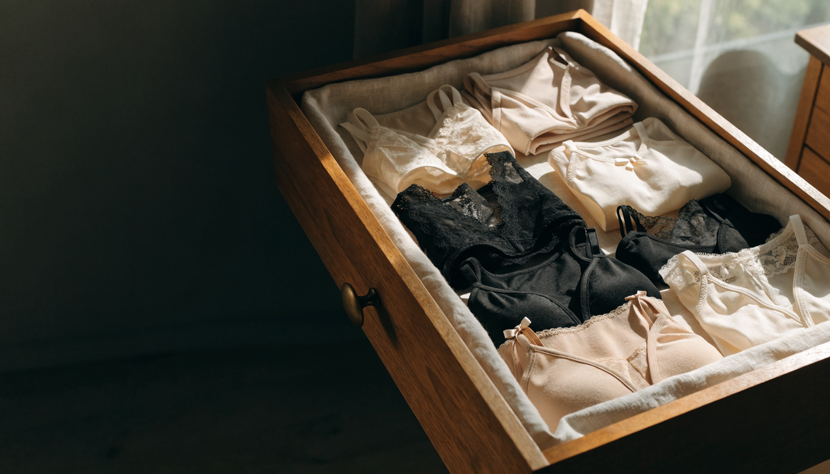 Tiroir ouvert garni de lingerie pliée en tons nude, noir et ivoire